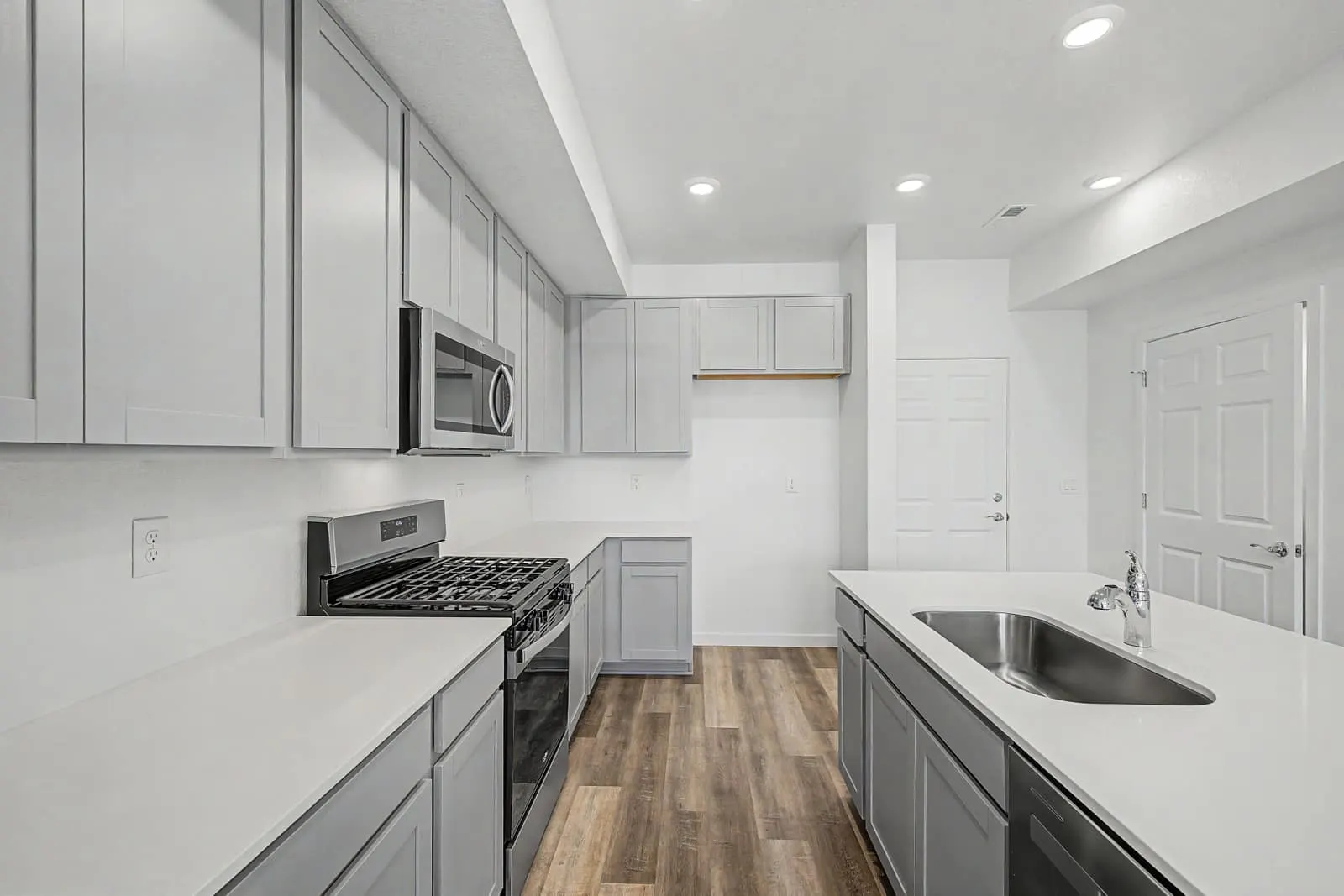 Kitchen with gas range and white cabinetry at 2897 E. 103rd Drive in Arras Park, Thornton, Colorado
