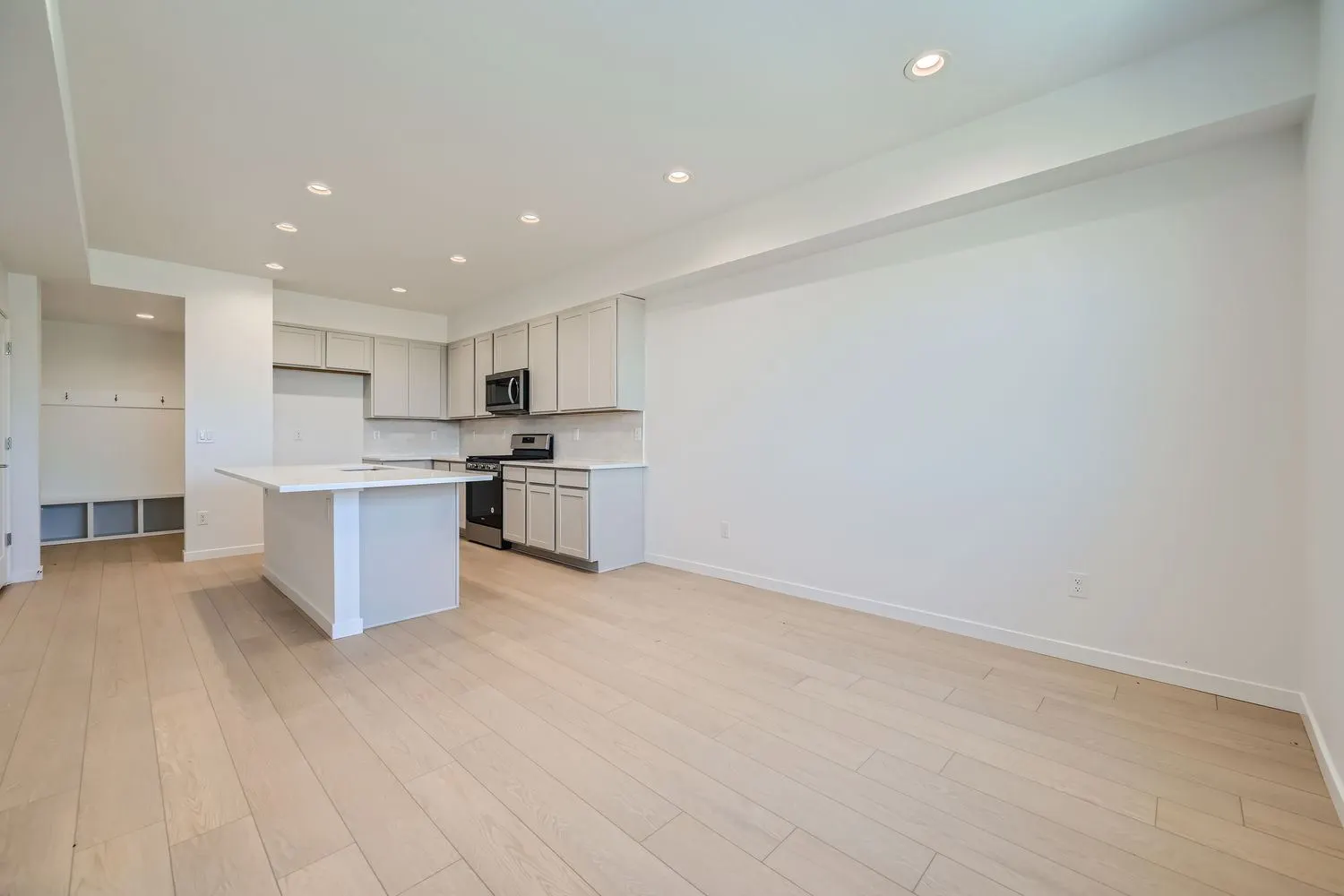 Open living area and white kitchen at 2969 E. 103rd Drive in Arras Park, Thornton, Colorado