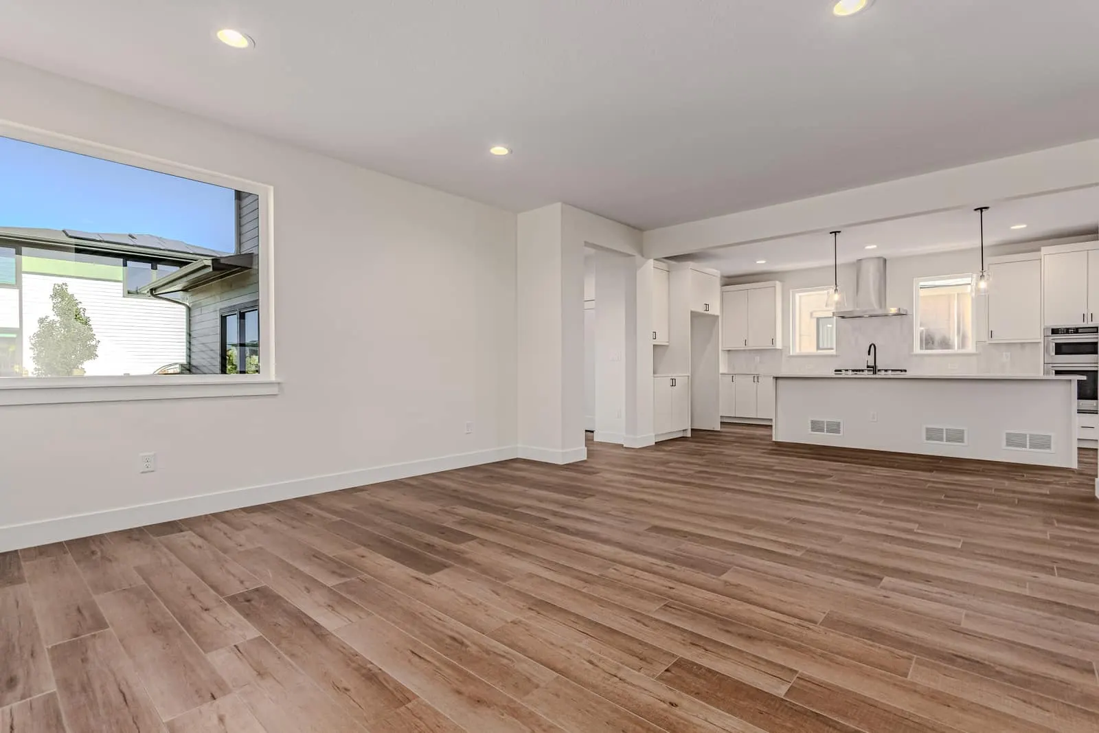 Open living area and white kitchen at 763 Mountain Drive in West Grange, Longmont, Colorado