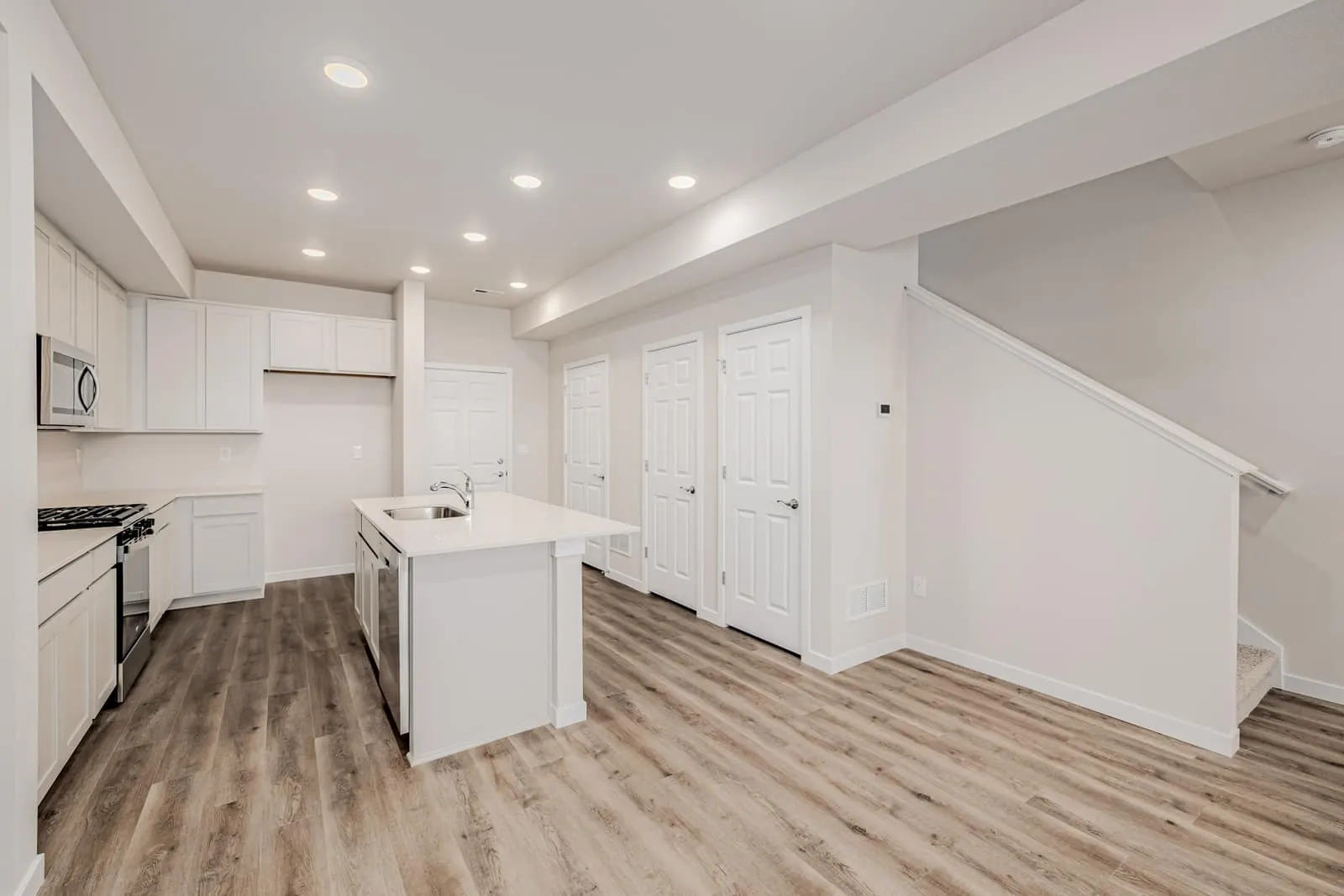 White kitchen and adjacent hallway at 2889 E 103rd Drive in Arras Park, Thornton, Colorado