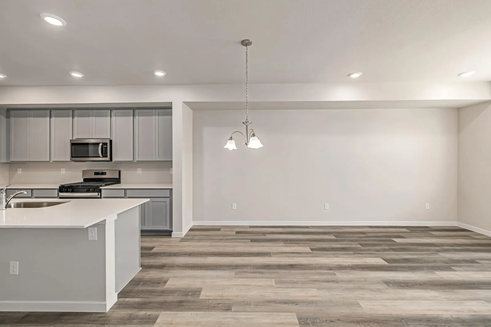 White kitchen with island at 2887 E. 103rd Drive in Arras Park, Thornton, Colorado