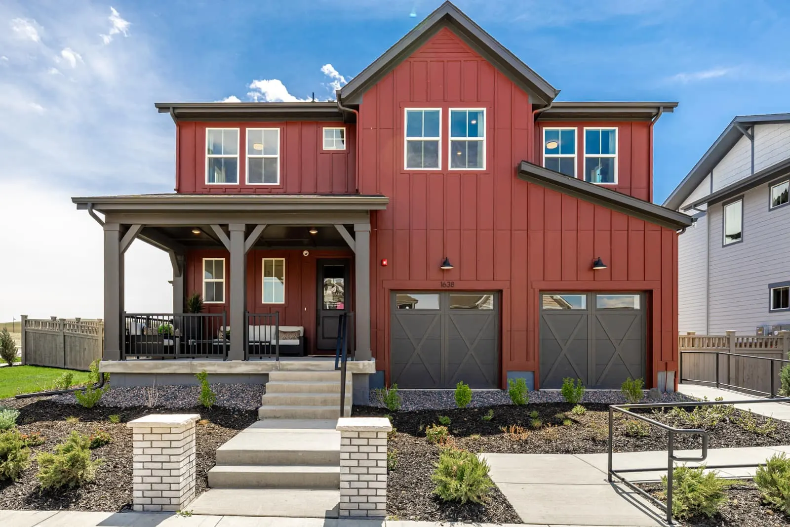 Red two-story home with covered porch at Westerly in Erie, CO 80516